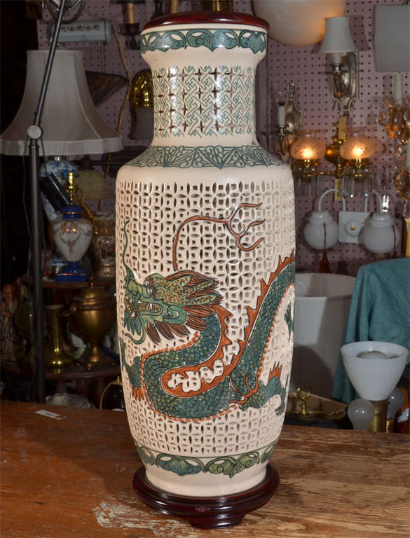 Reticulated Asian Pottery Jars as table lamps, lighted on inside as well as the top with whimsical,stylized Dragons Painted and glazed on the reticulated Jars. Jars are lined with rice paper generating a soft glow when the light in base is turned
