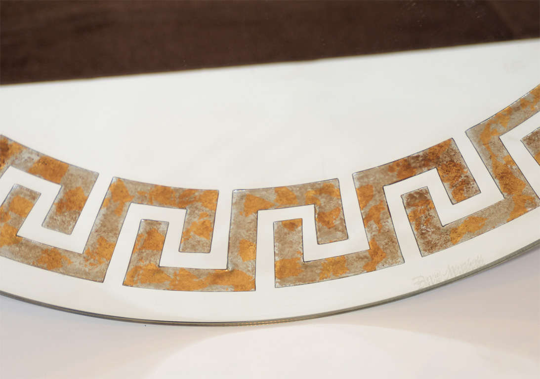 Elegant round mirror with Eglomise<br />
reverse gilt and silver leaf details<br />
with Greek Key design, and black<br />
lacquered exterior border.
