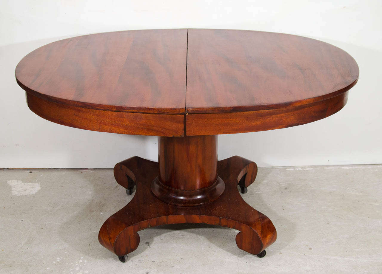 1900's mahogany veneer dining room table with two leaves extension. pedestal seating on X Carved Scrolled Feet.
the table measures 70 inches with the leaves and without measures 52 inches, each leaves measures 14.5 inches.