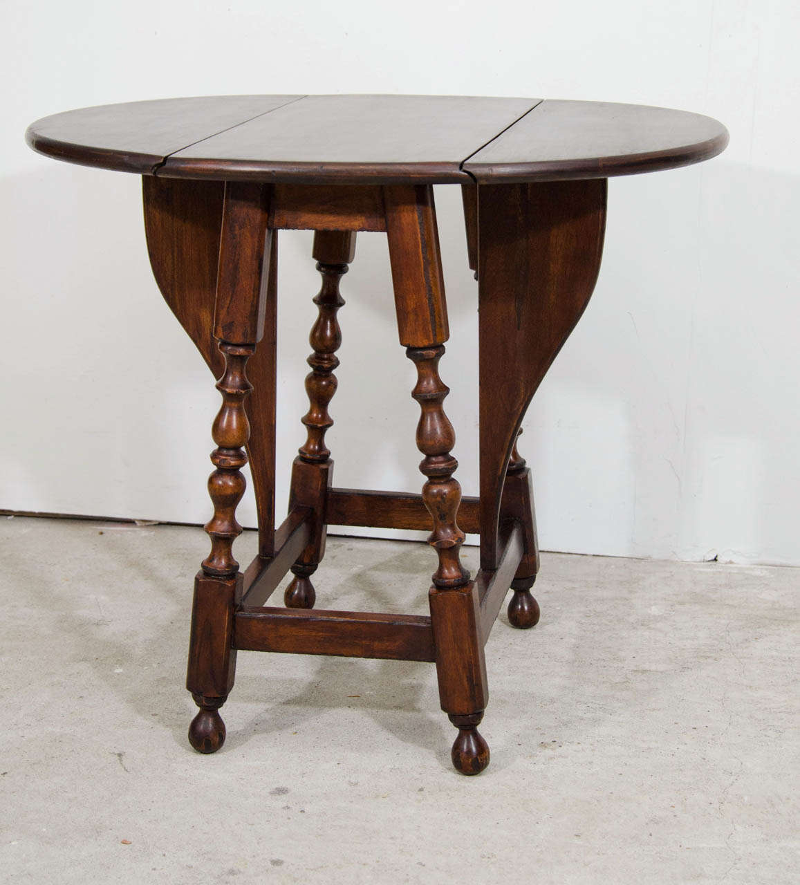 A British solid walnut Butterfly  Oval Drop Leaf Center Table with it's original patina.