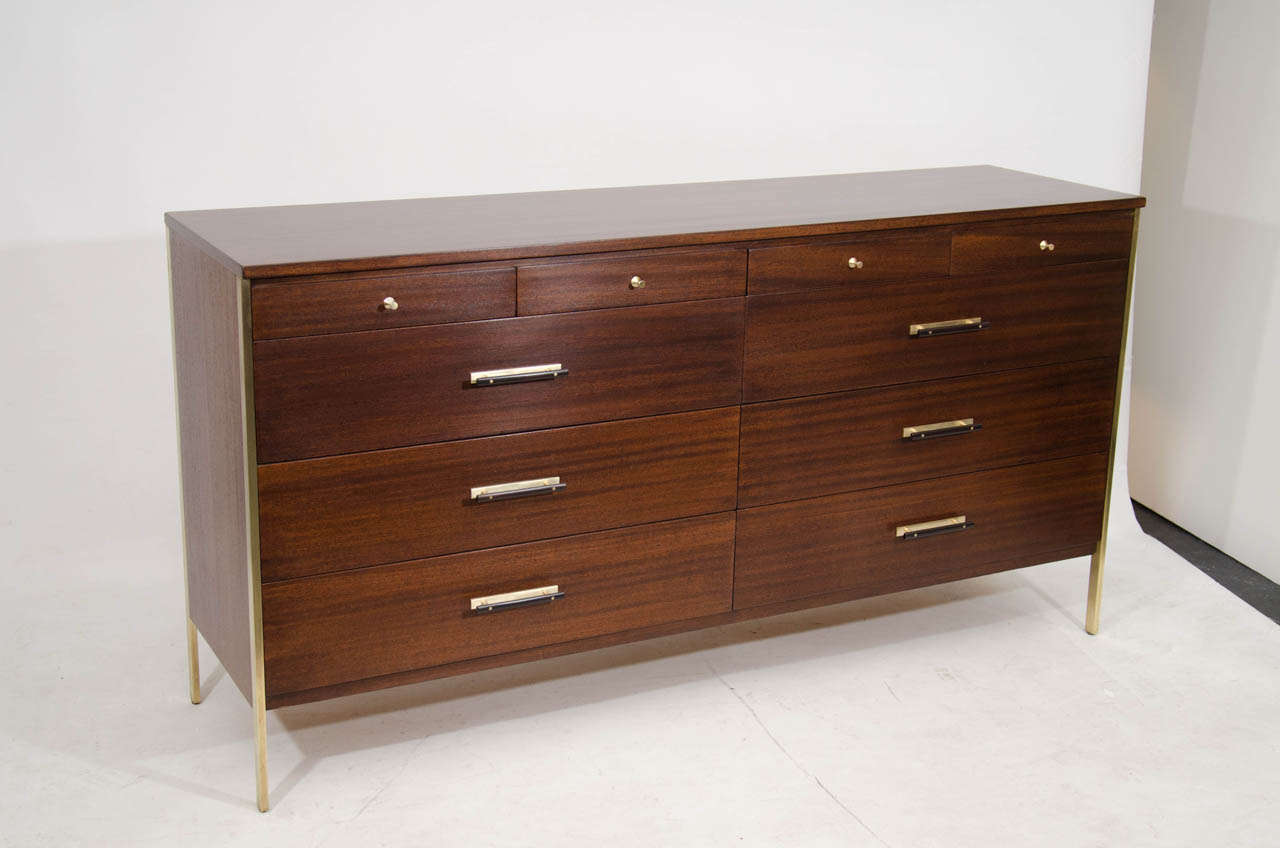 Very handsome dresser by Paul McCobb for the Calvin Group. Beautifully refinished in a rich brown stain and accented with brass frames that extend to the floor. A special feature are the horizontal wood and brass pulls. Quite nice! Please contact