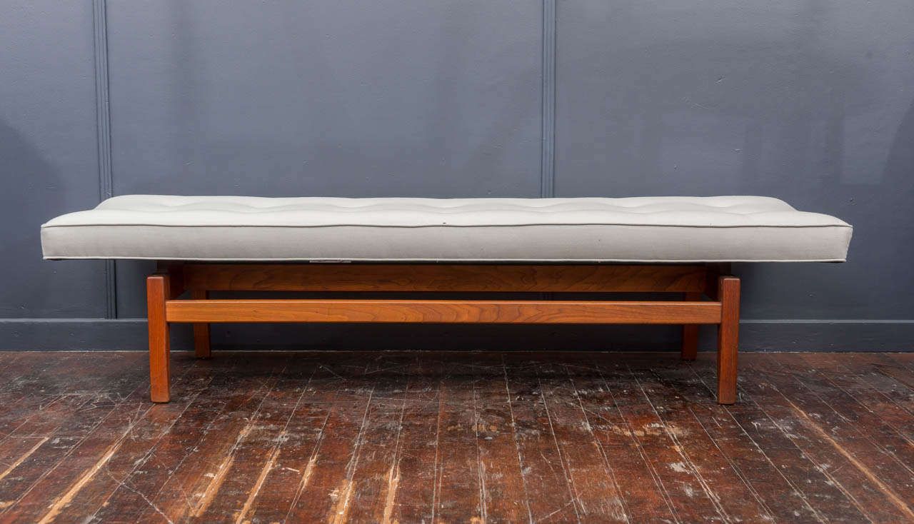 Rare larger size walnut bench designed by Jens Risom, newly upholstered in coin satin wool.