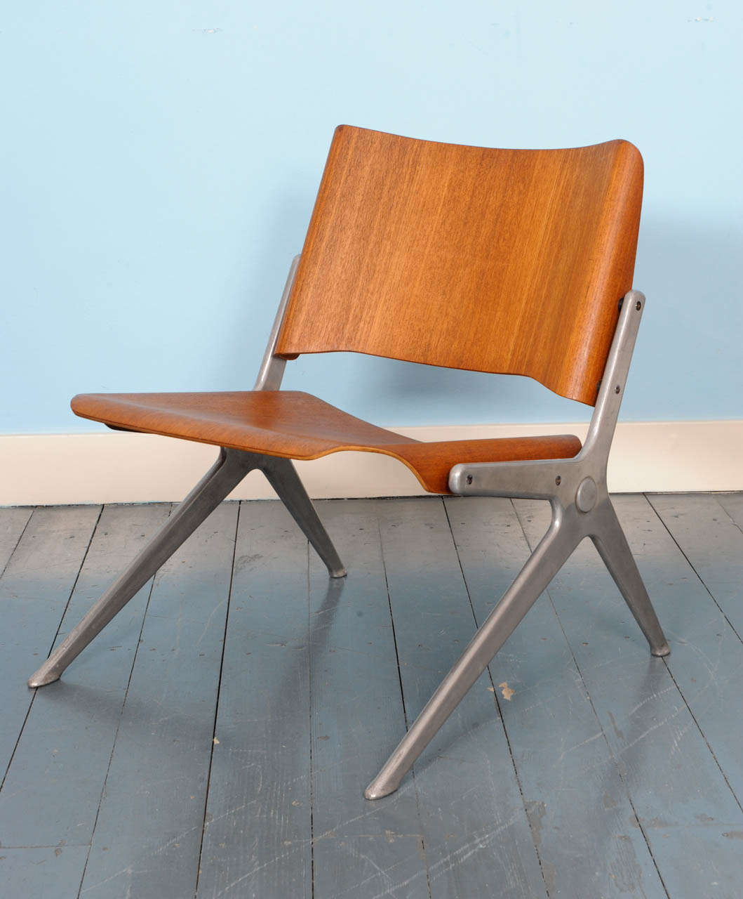 Rare Axis lounge chair by Robin Day for Hille Furniture.
This 1966 low chair combines injection moulded aluminum with bent plywood.
Most Axis chair were executed with upholstery, this version in teak faced plywood is very hard to find.
The Axis