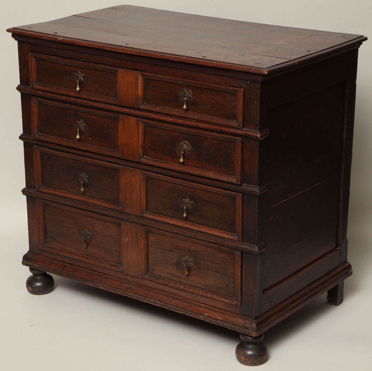 Very good English, 17th century oak chest of drawers, the thumb molded top over four graduated drawers, each with two molded panels with center dividing panel and each separated with half round moldings, the richly molded base over turned bun feet,