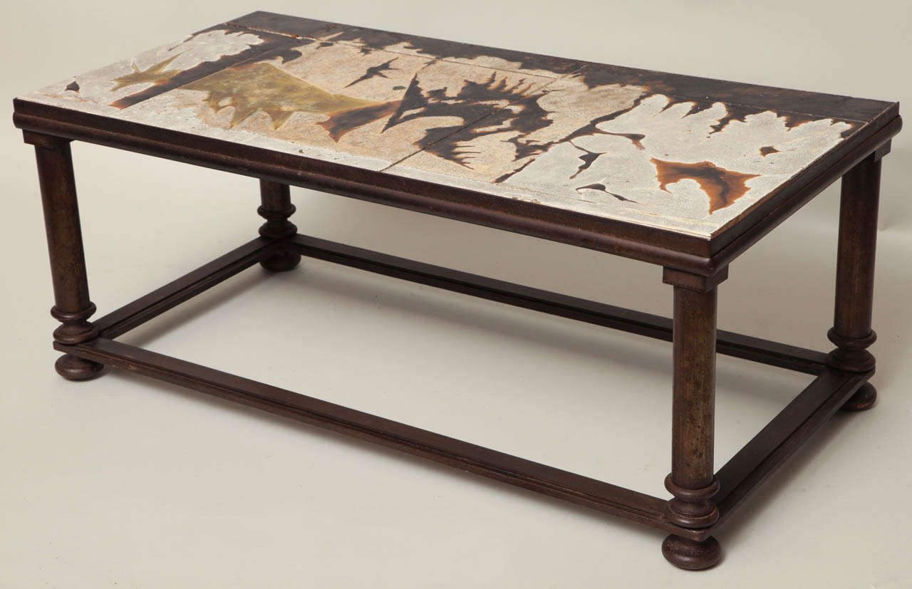 Very interesting 1950s bronzed iron coffee table with abstract patterned hand decorated and glazed ceramic tile top, indistinctly signed, of great scale and design.