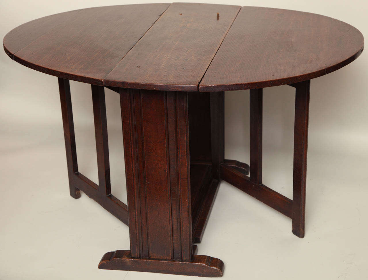 Very unusual late 17th Century English or Welsh oak gate leg table, the richly patinated oval top over molded plank ends on shoe feet, the swinging gate legs hinged on the molded platform base, the whole possessing wonderful color.  A similar table
