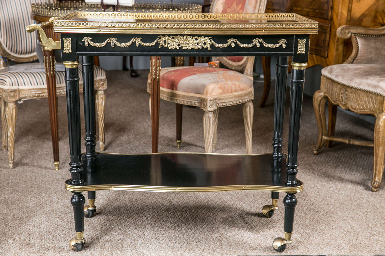French bronze-mounted tea wagon by Maison Jansen. This gorgeous serving cart has fine all-over bronze mounts and is typical of the finest work put forth by this renowned furniture designer. Sitting on study rolling casters the bronze framed lower