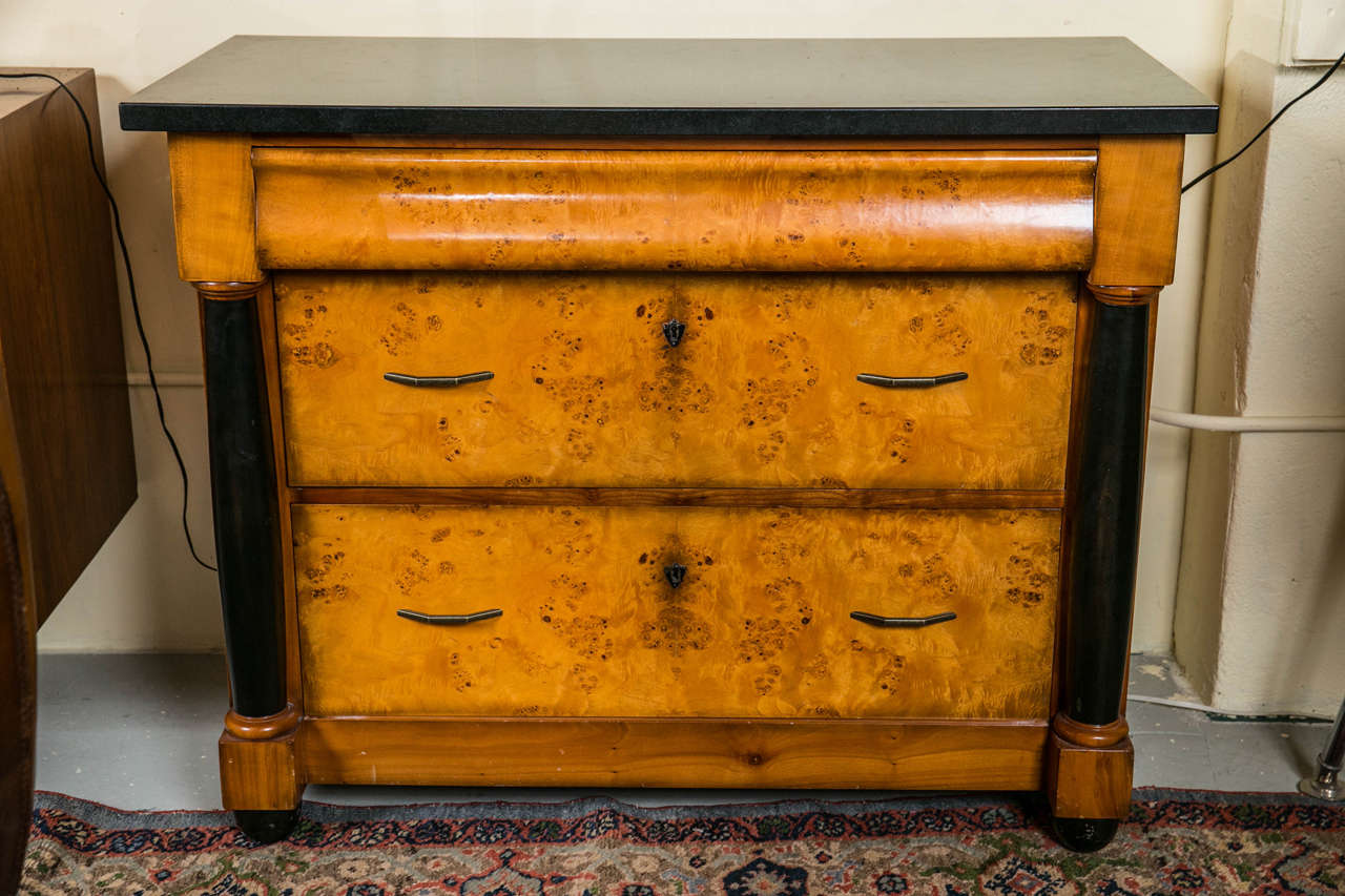 Pair of black marble-top Biedermeier style commodes. Pair of fine Italian Biedermeier style three-drawer commodes, nightstands. Each case of wooden construction having two lower drawers with pulls under a hide-a-way top drawer. The drawers flanked