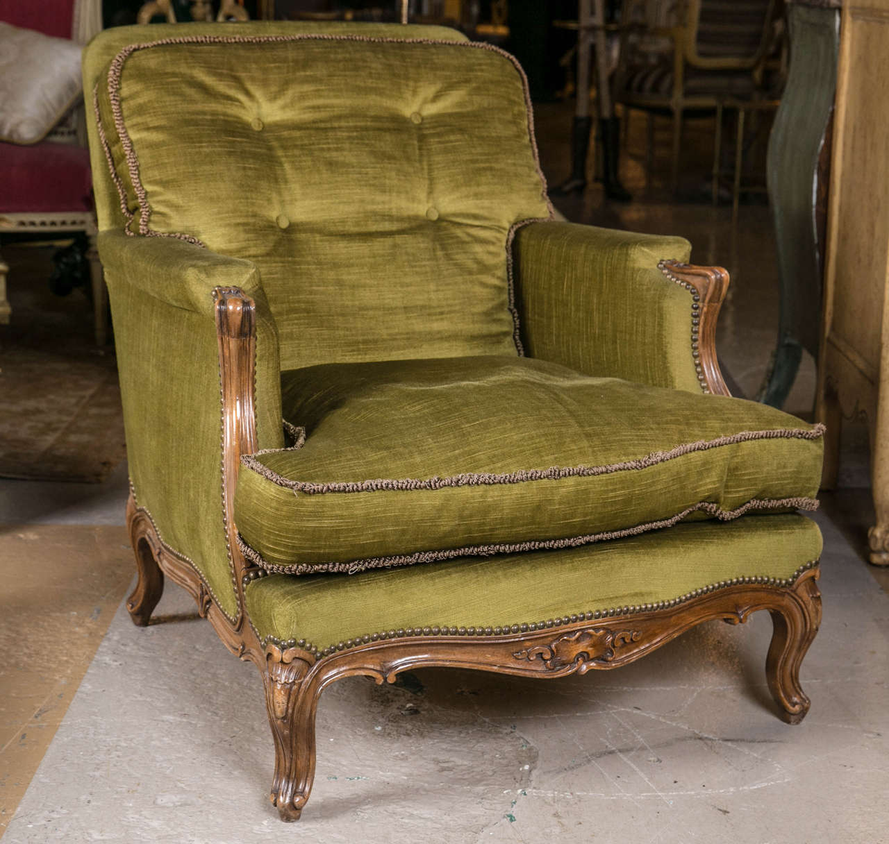 Pair of French Louis XV style bergère lounge chairs by Maison Jansen. Finest pair of carved Louis XV style arm - lounge chairs. The carved legs and apron leading to a pair of swaying armrests. The velour type upholstery having a cushion back and set