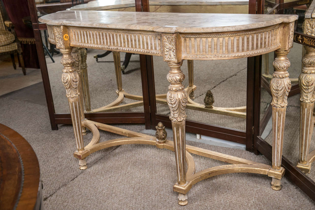 Louis XVI style marble-top console in the manner of Maison Jansen. This very decorative Hollywood Regency style console has a very fine washed finish with the Louis XVI style legs supported by a matching undercarriage with a central finial flame