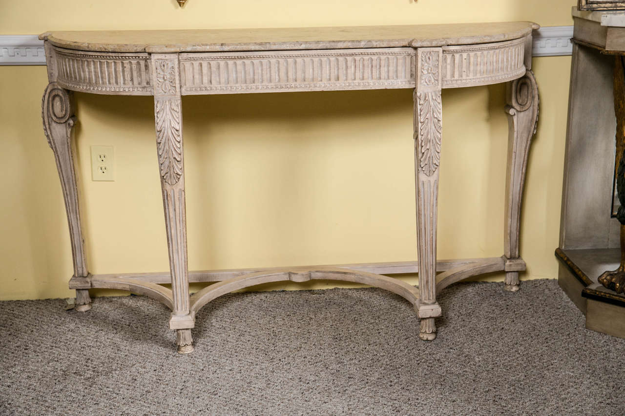 Louis XV style marble-top console in the manner of Maison Jansen. A white washed marble-top console in the Louis XV style. The curved legs leading to cabriole tops terminating in floral corners. The demilune reeded apron supporting a marble top. A