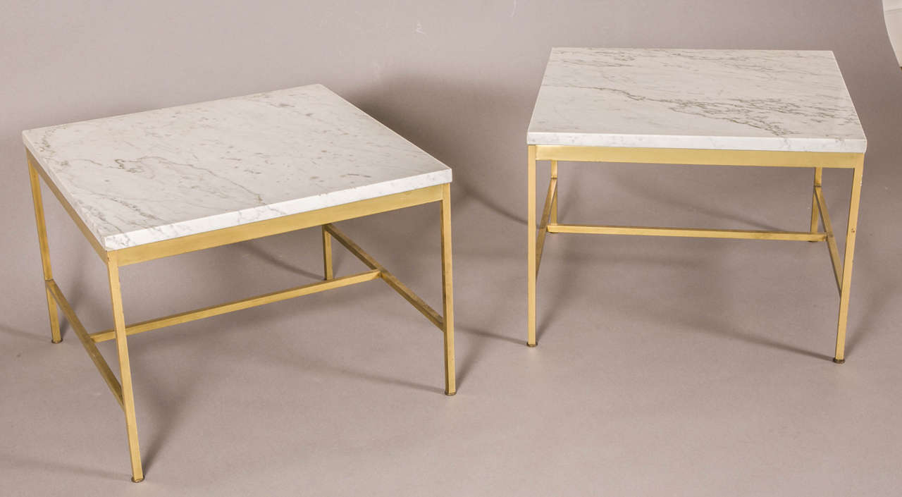 Pair of square coffee tables, 1960-70, by Paul McCobb, USA (1917-1969)
with a white Carrara marble top resting on a gilt brass base with H cross-bar.

Working first as a decorator and designer in New York por the Martin Feinman’s Modernage
