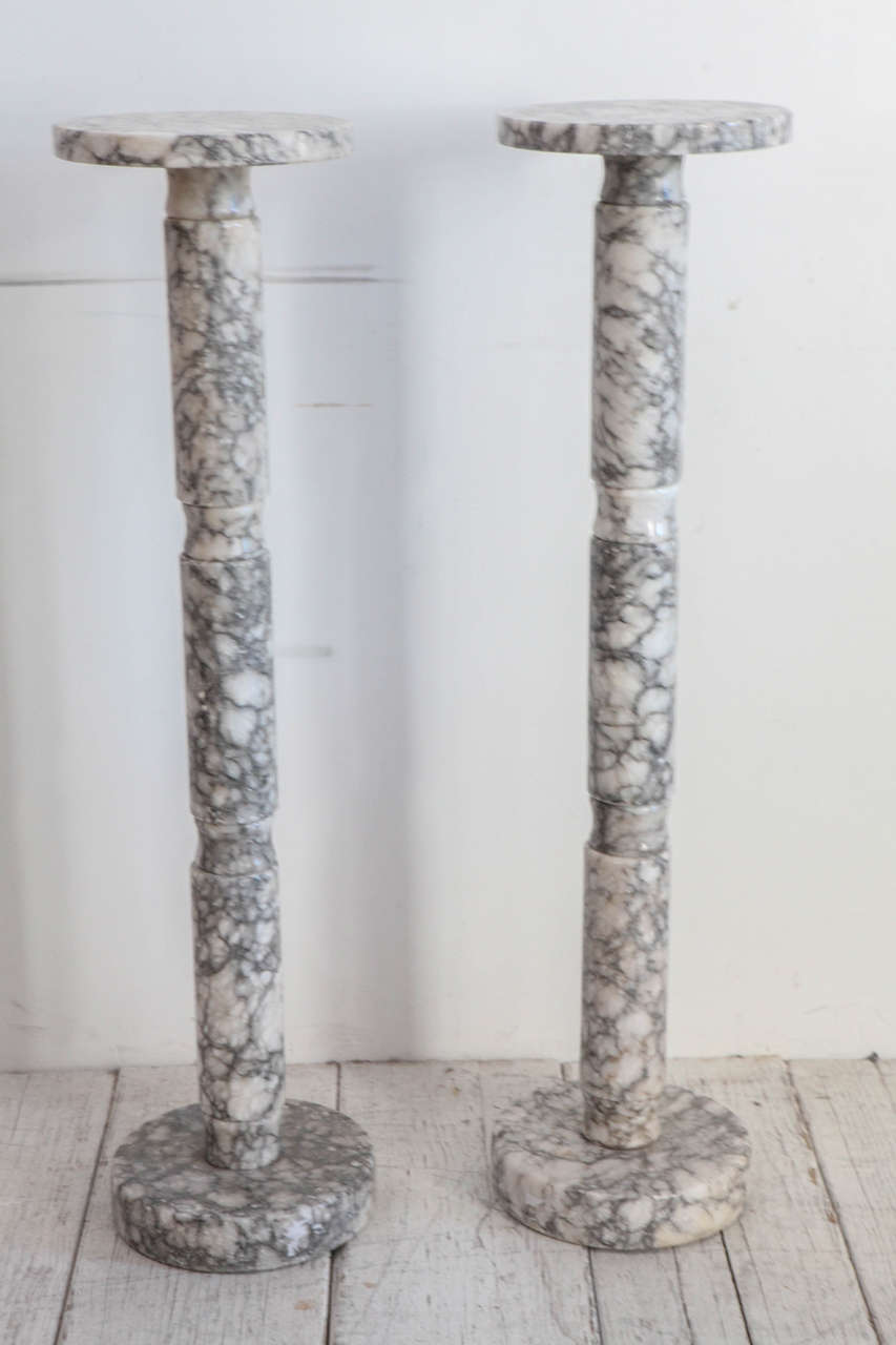Beautiful grey and white marble pedestals in long cylindrical form.