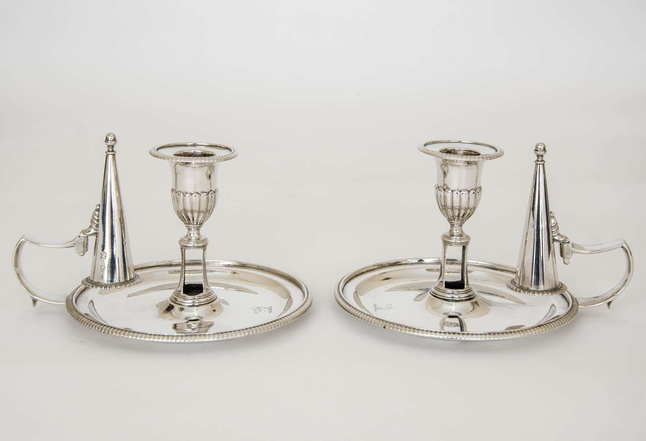  A pair of exceptional, George III Antique Silver Chambersticks. They are of plain circular form with the lower portion of the bell shaped capitals being embellished with fluted decoration. The removable nozzles have a gadroon border, as do the