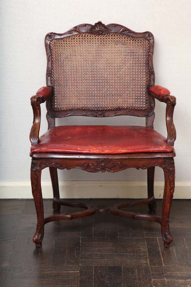 A Very Nice Carved and Stained Regence Fauteuil with Caned Back and Flat Uphostered Leather Seat. France 18th Century