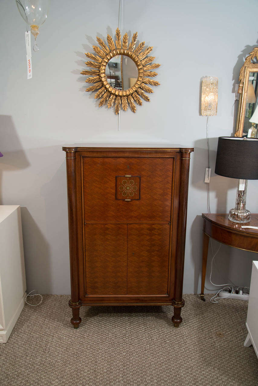 This magnificent signed bar cabinet, designed by Jules Leleu, has both style and substance.  Its exquisite workmanship, including the fine marquetry, brass detailing, nickel plated hardware, and the floral medallion (characteristic of Leleu), make