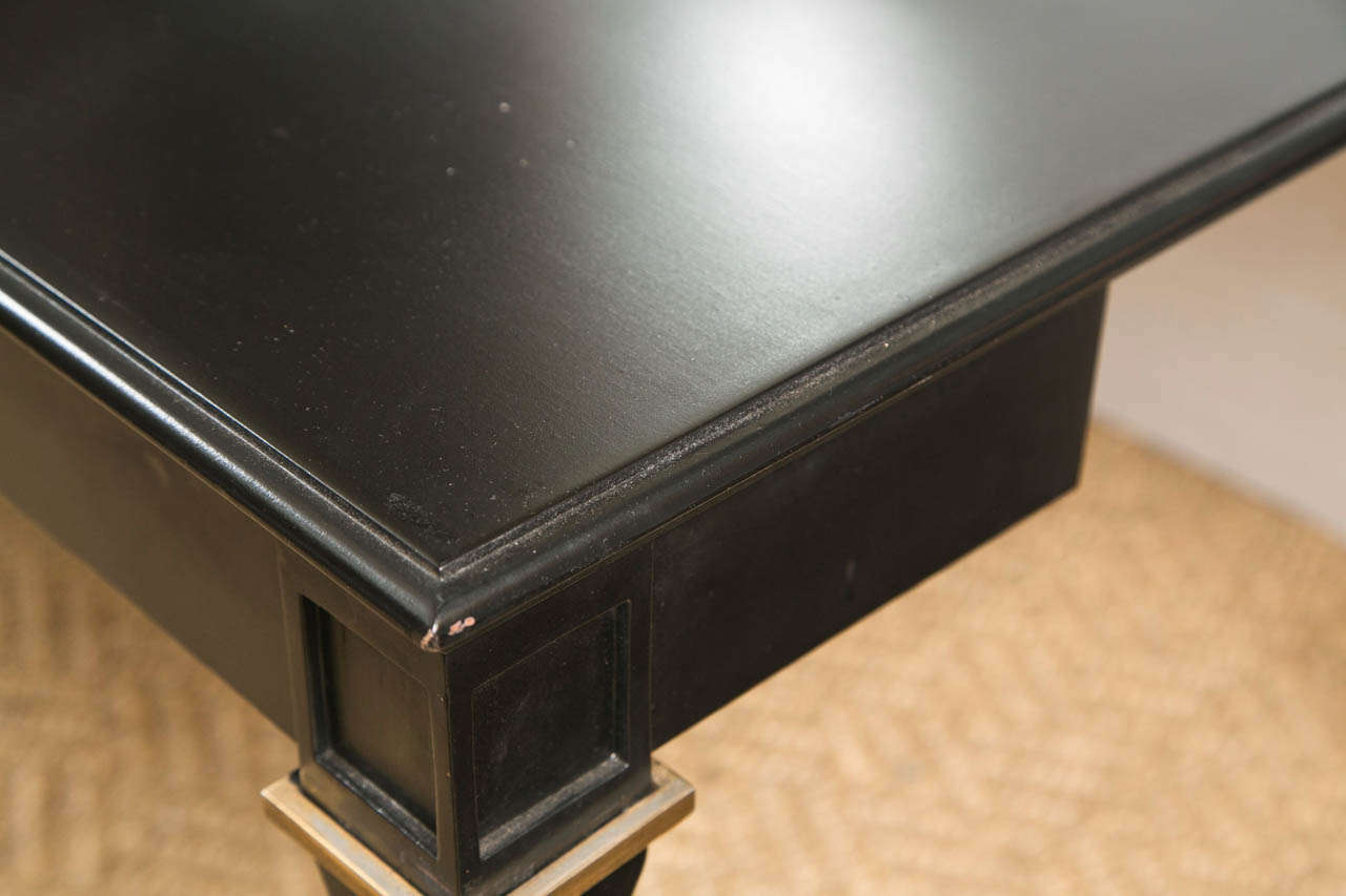 A fine Ebonized Console - Dining table by Maison Jansen. This console with ability to flip open and turn into a full sized dining table is finely bronze mounted. The bronze mounted tapering legs leading to a console top that when flipped open easily