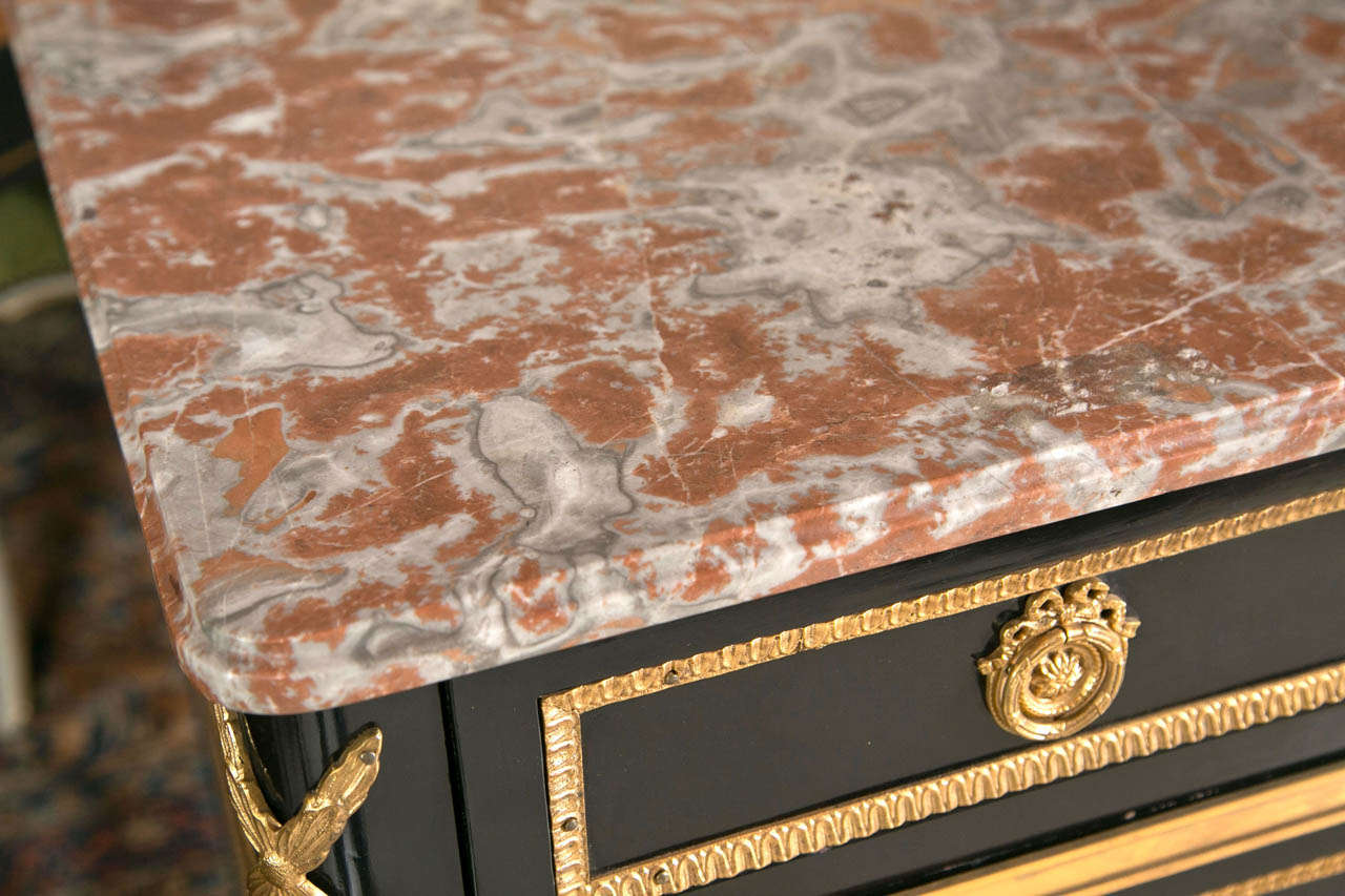 Absolutely the finest Maison Jansen commode. This wonderfully ebonized commode having heavy bronze mounts in the Louis XVI style. The sabot capped feet leading to tapering legs toped with bronze casted mounts. The lower apron with a heavy bronze