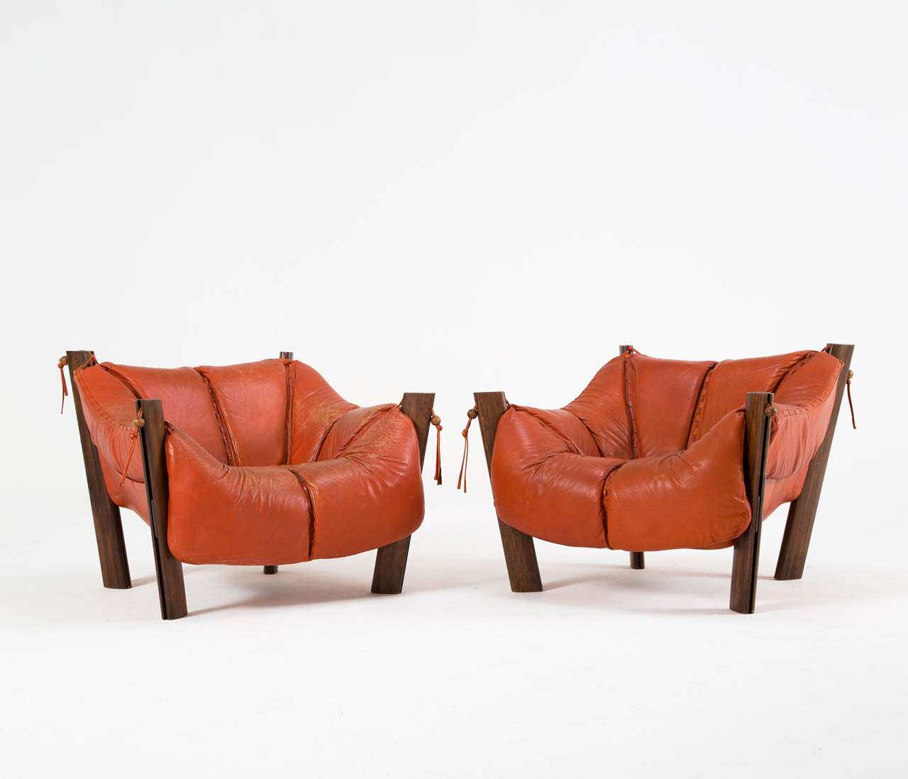 Pair of lounge chairs, in jacaranada and leather, by Percival Lafer, Brazil, 1960s. 

Set of two easy chairs by Brazilian designer Percival Lafer. These chairs consists of a solid jacaranda base in which the leather seating 'hangs'. Soft cushions