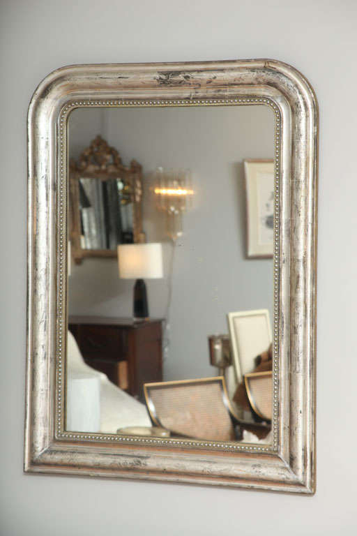 A Louis-Philippe silvered wood mirror with beautiful floral detail and inner beaded molding.