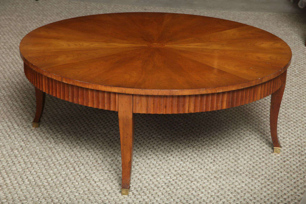 A striking round walnut coffee table with a burled walnut medallion in center, a molded apron and elegant splayed legs.