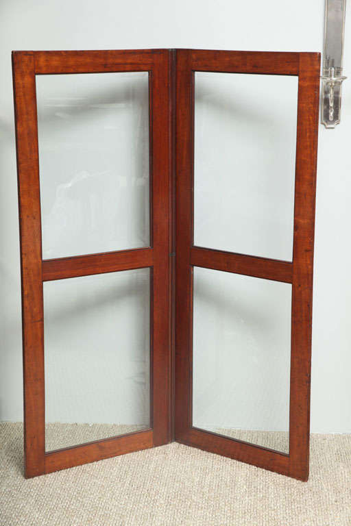 An English mahogany two-fold screen with beveled glass and beautiful covered hinges.