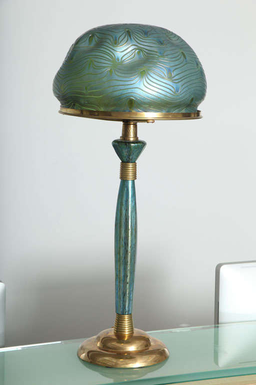 An Austrian Art Nouveau gilt bronze and glass table lamp designed by, Leopold Bauer for Loetz with decorated iridized blue dimpled Loetz shade and matching base.