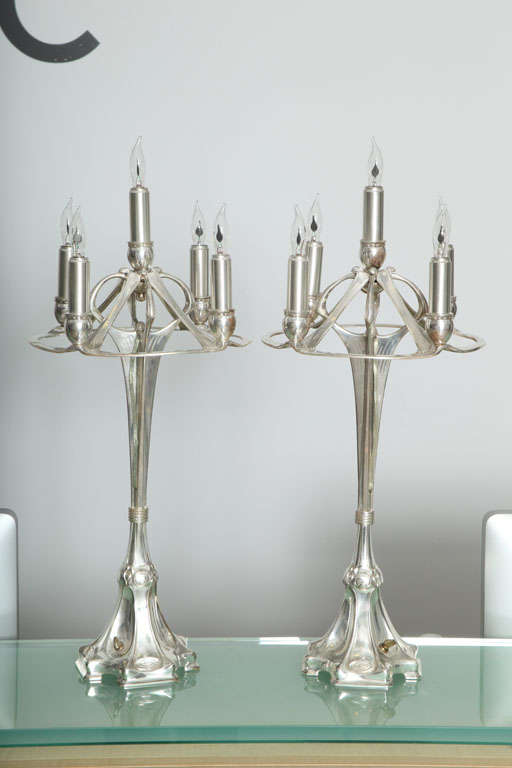 An Austrian Art Nouveau pair of silvered bronze candelabrums each with five stems graduating into an organic base. The lamps are unsigned.