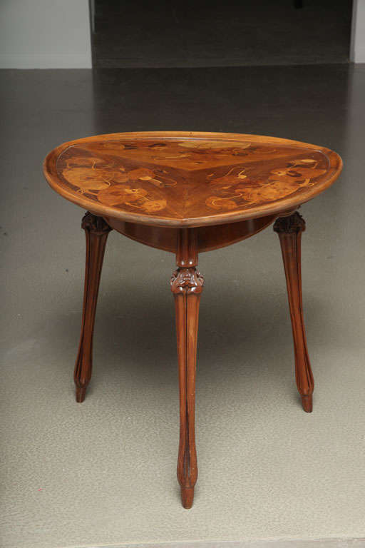 A pair of French Art Nouveau carved mahogany & marquetry table by, Louis Majorelle decorated with exotic fruitwood marquetry morning glory decoration on the table top and further decorated with carved wood legs with floral decoration.