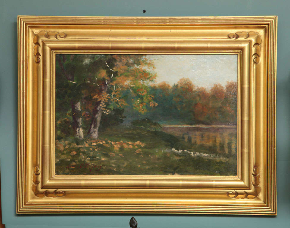 An AMerican oil & canvas landscape painting by, Louis Comfort Tiffant depicting an Autumn Lakeside Landscape. The painting is signed 