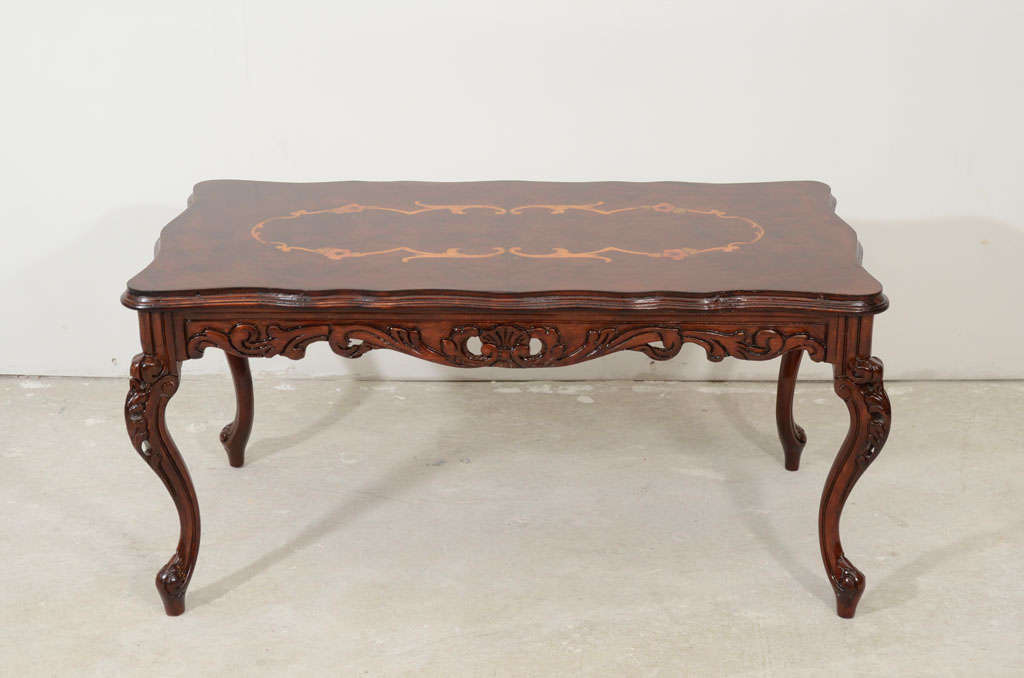 An Italian carved coffee table with cabriole legs. The base and legs are carved and has a Rococco shaped.Late 19th,the top has beautiful design of marquetry.