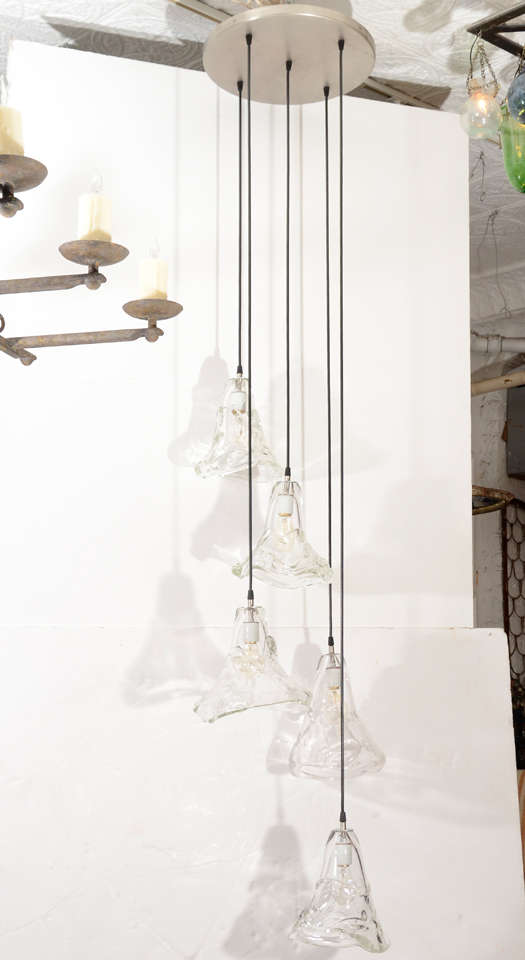 Original Design.  Custom options available.
Five handblown glass pendants are suspended from a circular metal canopy.  Great for entryways, stairwells.