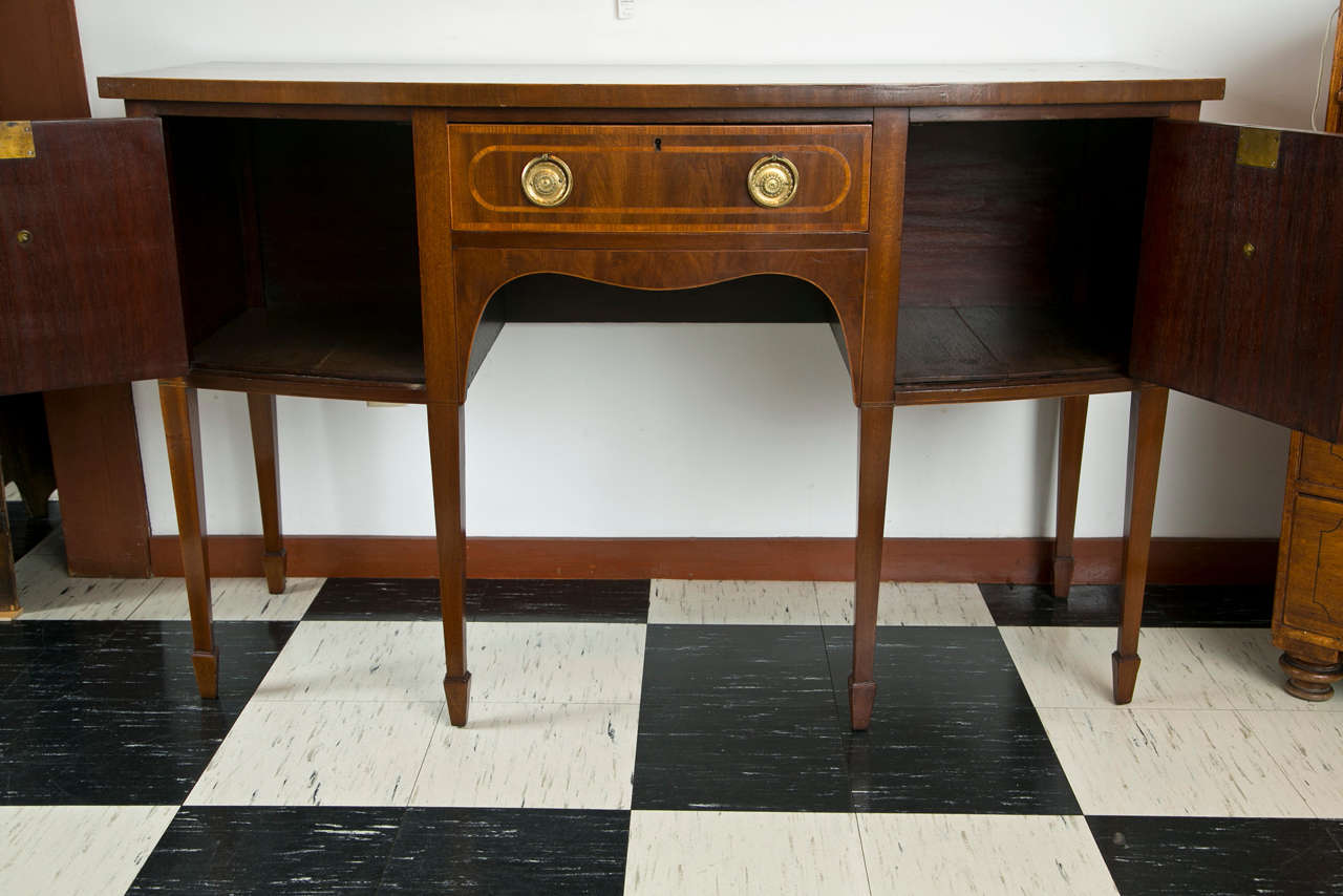 Even at 60 inches in width, this little sideboard does not lack for panache--the satinwood inlays take care of that as they run along the top edge and across the doors and drawer. Large brass ring pulls are at home on the front of this bold piece,