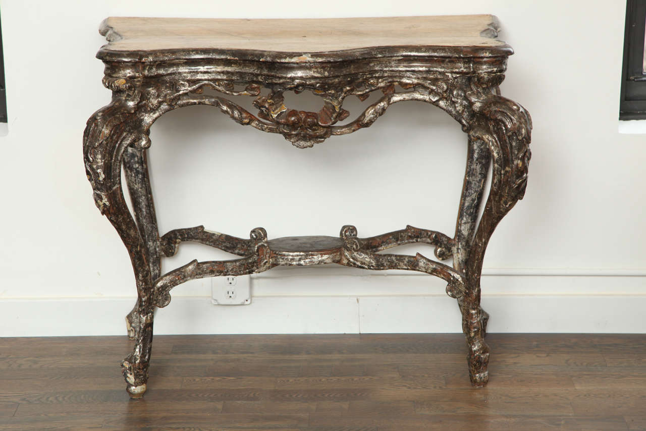 Italian Baroque hand carved console in metal gilt-wood with amazing age and patina. The top was hand painted faux bois in the perfect yellow with grey veining. This is a stunning piece which looks amazing in a Modernist setting.