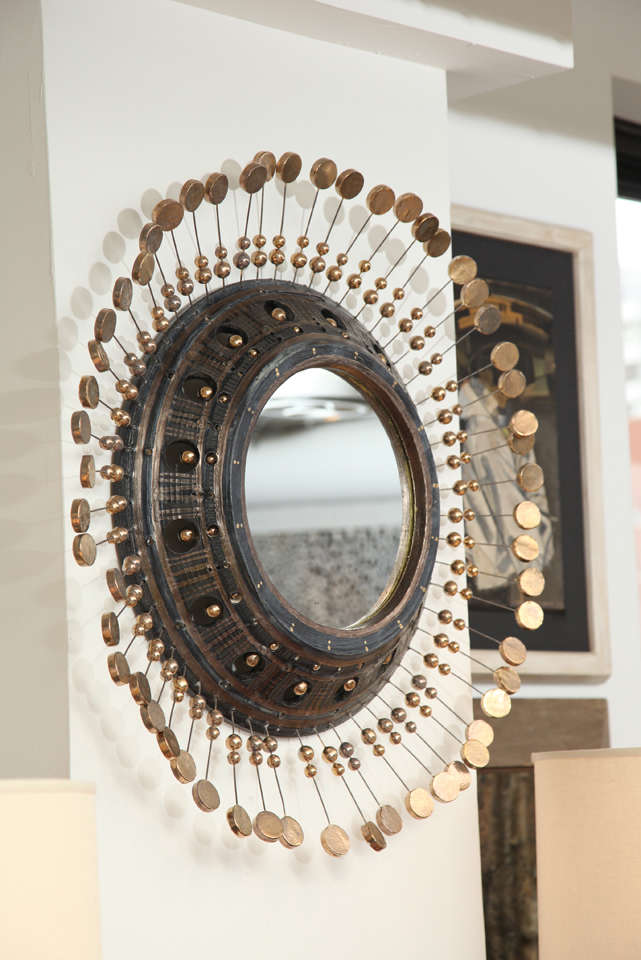 Black glaze over ceramic embellished with gold paint, detailed with crackled glaze balls and disks on wire to form a stunning starburst mirror.
France 1940