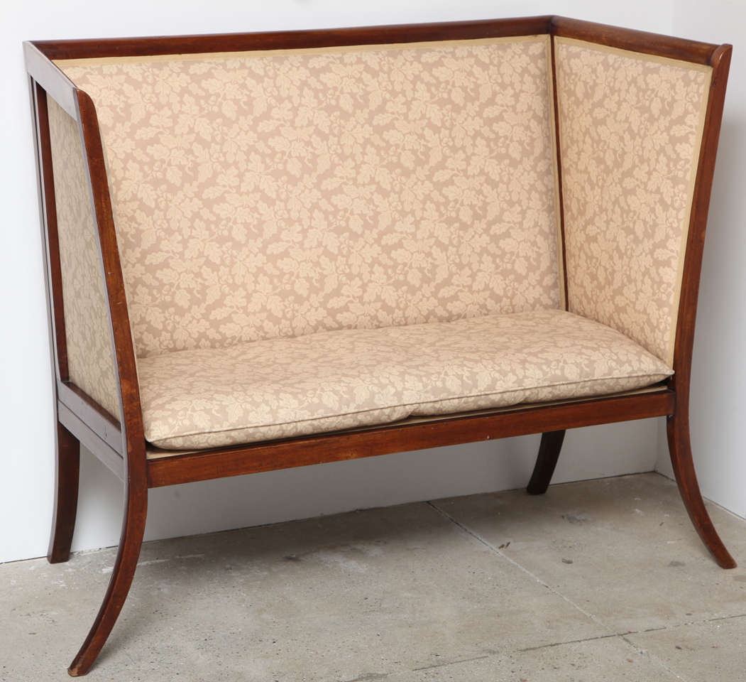 English mahogany hall sofa upholstered in acorn print fabric with wood frame.
