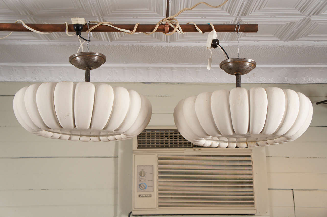 A unique pair of circular ceiling fixtures, circa 1925 to 1935, with ribbed organic design. Hand tooled plaster, with dry white surface, and central glass panel.