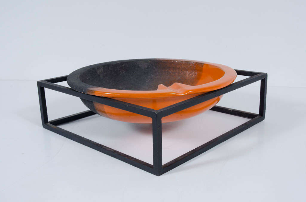 A graphic ashtray comprising a circular ceramic dish in black and orange glaze supported on an open cube metal frame.  Signed to the base '8388 B Italy'. By Bitossi for Raymor. Italian, circa 1960's.