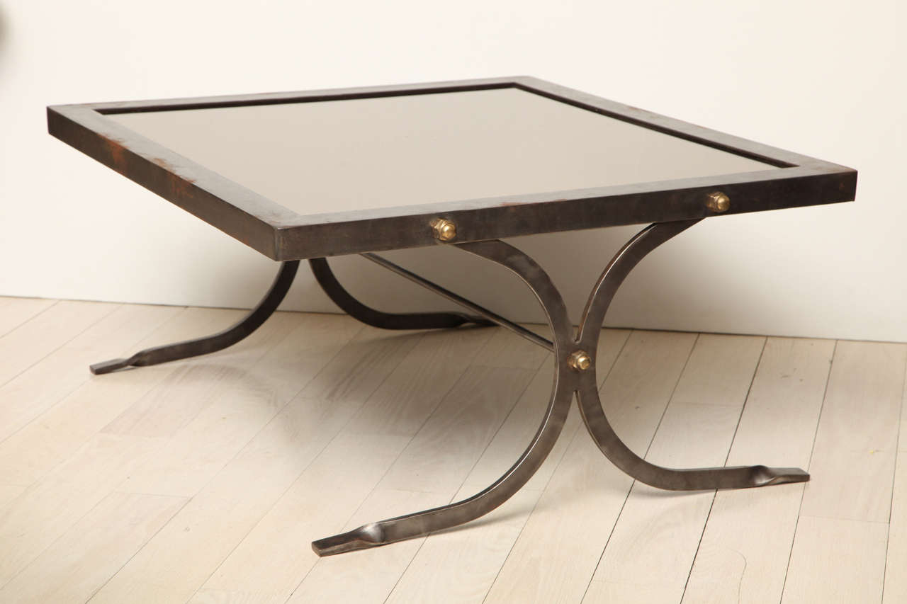 Pair of polished steel coffee tables with smoked mirrored tops and brass trim, by Jansen.