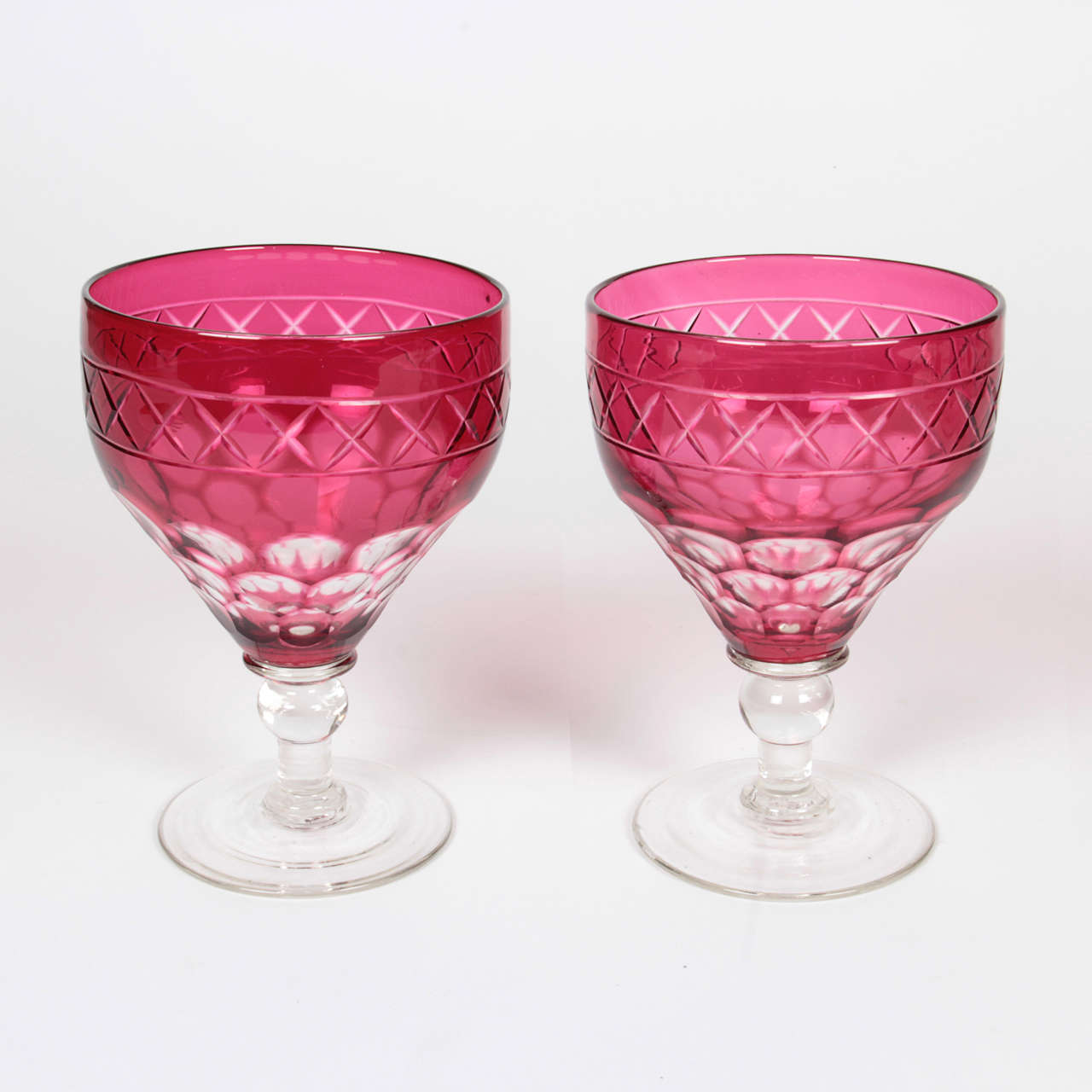 Set of 10 classically styled ruby cut to clear wing crystal goblets. Classic elongated thumbprint design, knob stem with crosshatch design on ruby collar. Attributed to Webb, England.