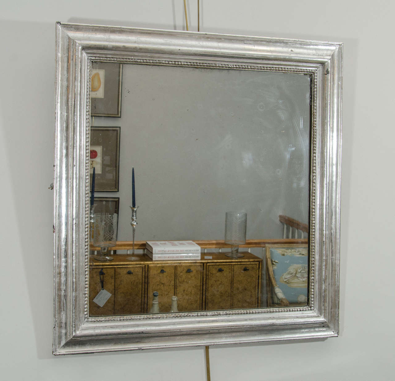 A square mirror in silvered wood with inner beaded molding, French, 19th century.