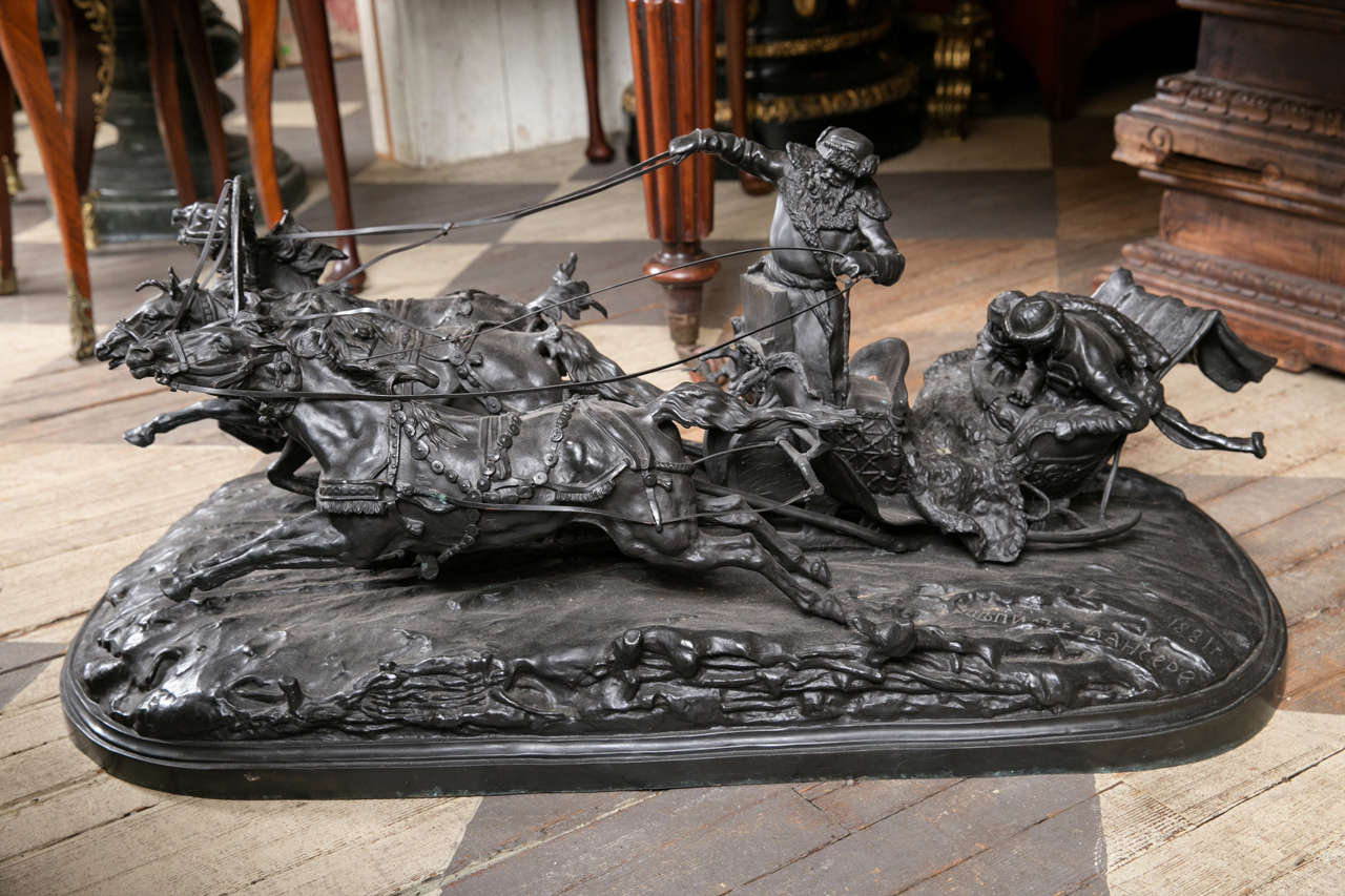 Signed in Cyrillic  this bronze is typical of Russian bronzes of similar genre.
 Three horses are galloping at top speed while pulling a sled across the snow. The sled is being driven by a  bearded man, standing and holding the reins. In the back of