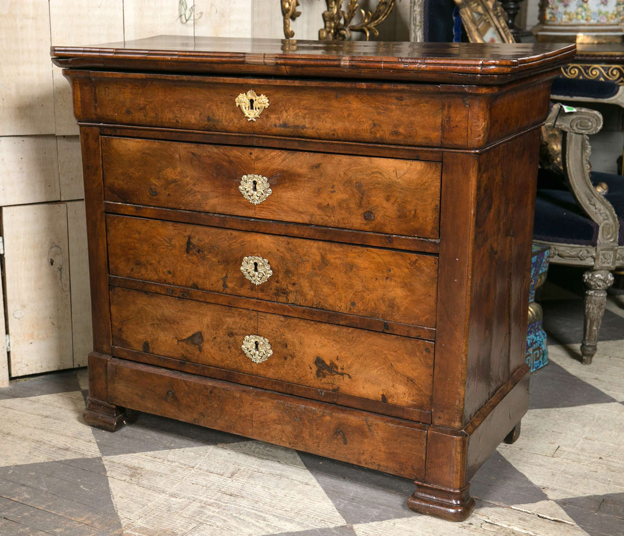 This chest is constructed of both solid and veneer walnut. The top is walnut.
The top drawer is shallower than the rest. Brass escutcheons decorated the drawer fronts.