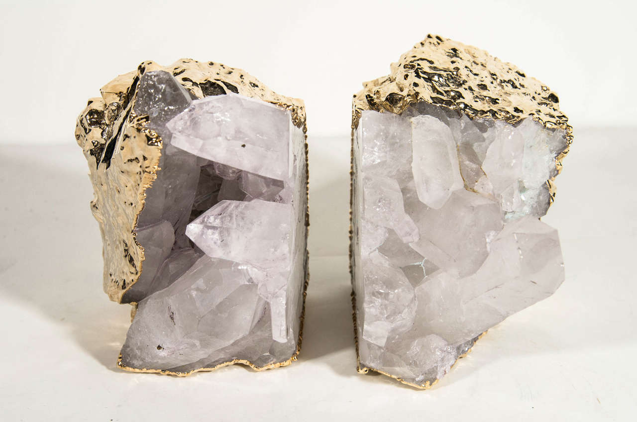 Outstanding pair of rock chunk crystal quartz specimens with rough egdes wrapped in 24K gold plating. Can be used as bookends or as decorative objects. Exquisite natural forms with protruding wedges of quartz throughout.
Each specimen measures