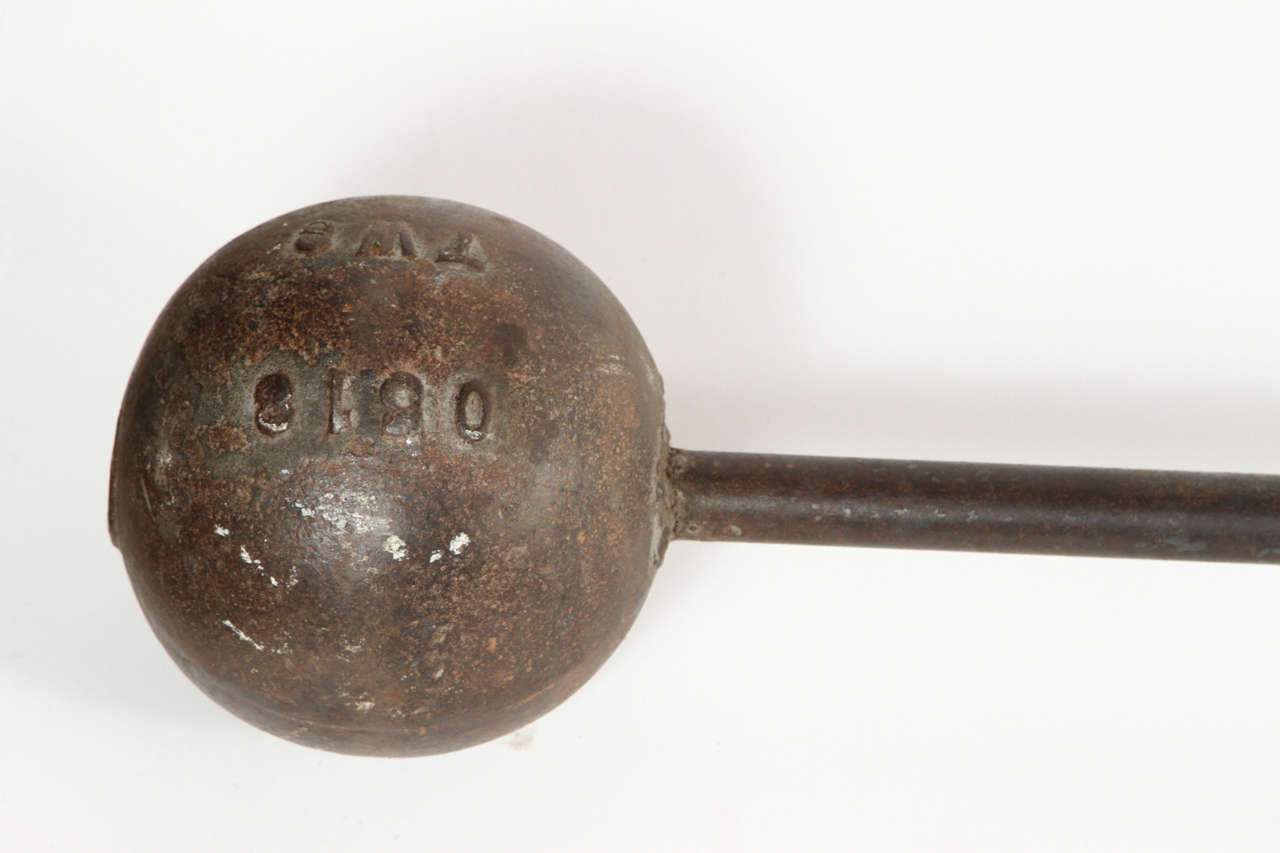 Early cast iron strongman barbell weighing approximately 60 pounds. Made in America circa 1890s.