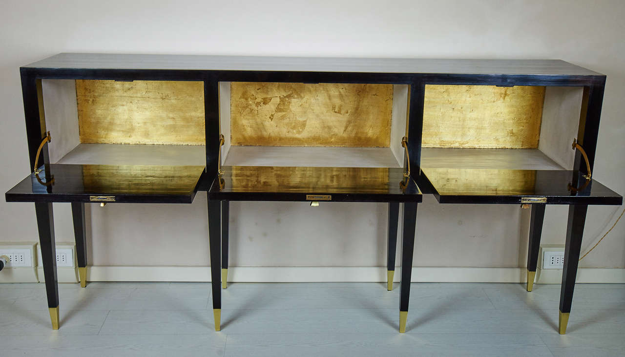 Black lacquered walnut and bronze details.
Folding doors, the side is beige lacquered and gold leaf.
Interesting proportions, not to narrow.
For similar example examine, Stile July 1942 pag.116.