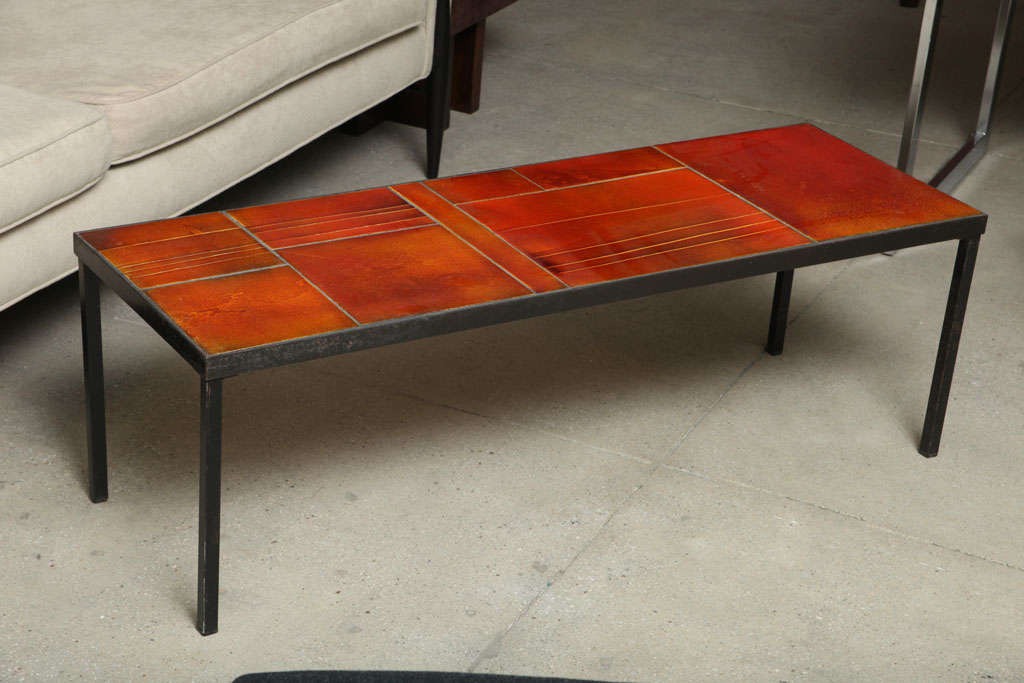 This table has a slim profile and features amber-hued tiles with a seemingly inner glow, arranged of subtle variations and nicely balanced.