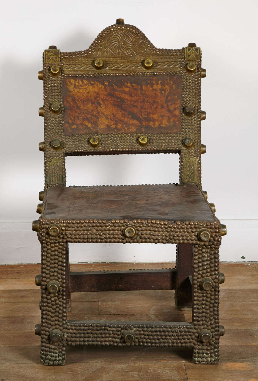Great Ashanti king's chair, hand carved wood frame covered with hammered brass tacks and studs. Leather seat and back.

Ghana, late 19th century.