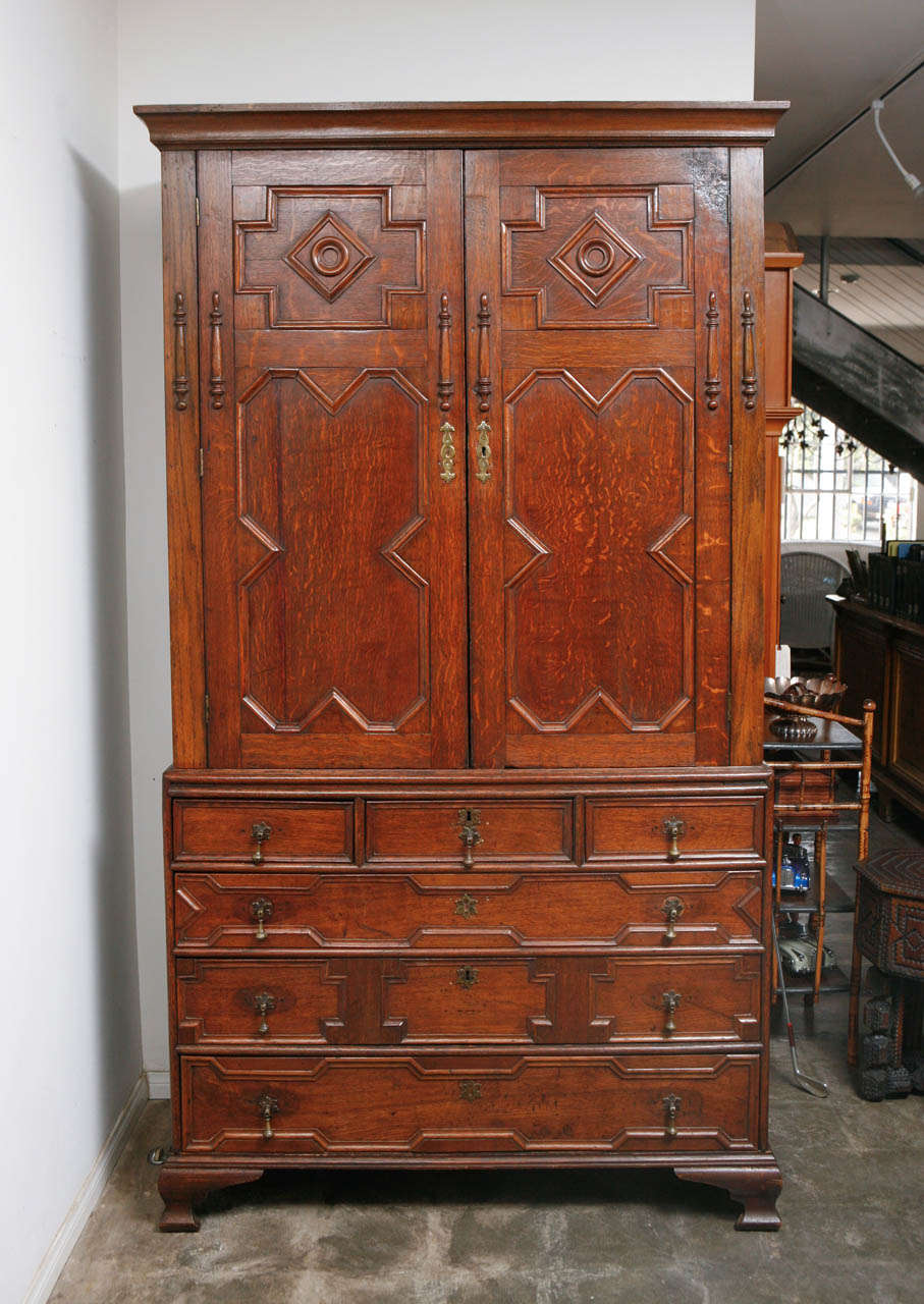 This George III oak Linen press has two doors over three drawers press was made in the 1790's and updated in the 1870's  with drop handles on the drawers and repairs to the molding.