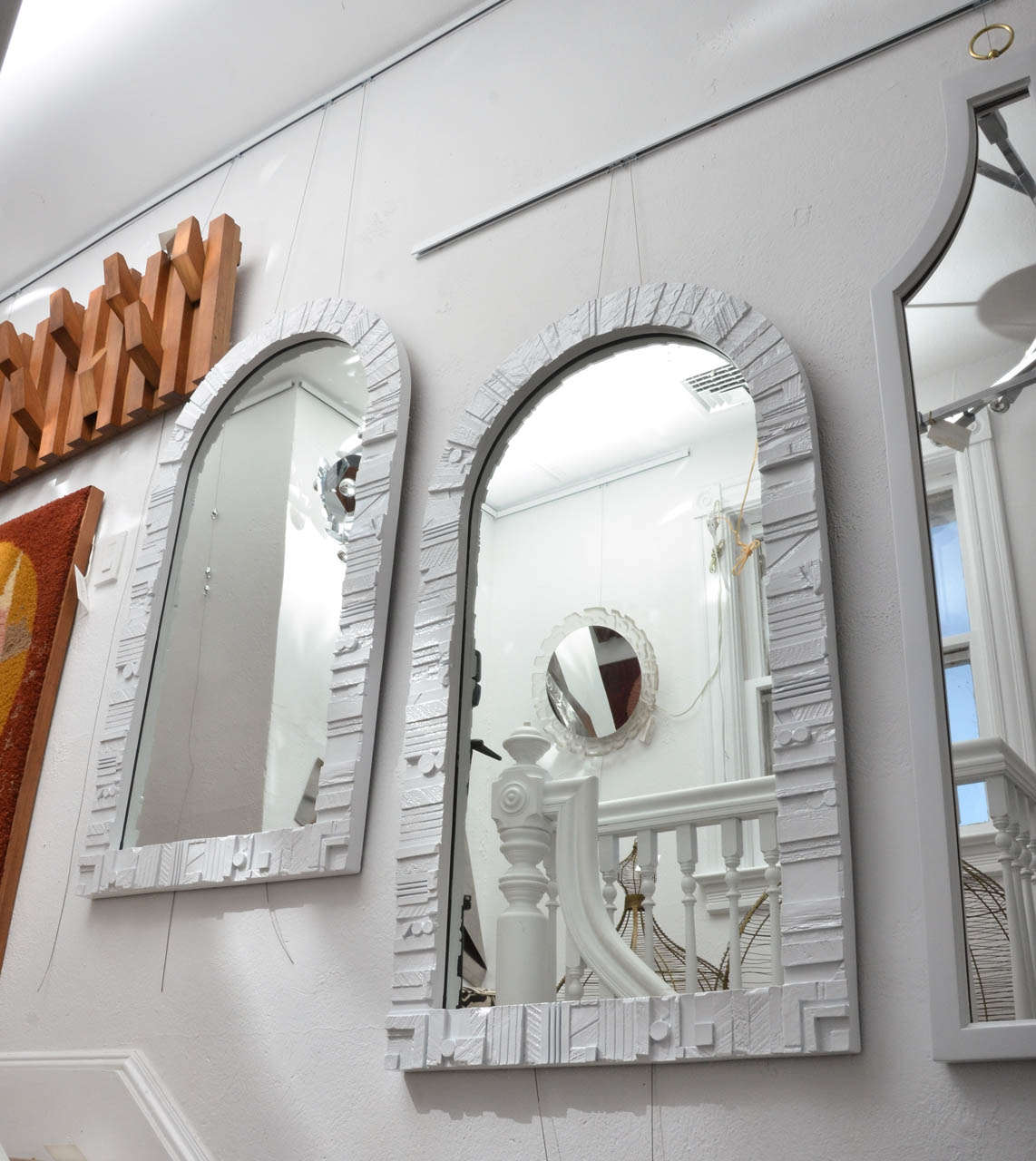 Pair of white lacquered wood frame sculptural arched mirrors.